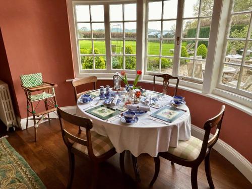 a dining room table with a white table cloth on it at The Old Rectory Somerset in North Perrott