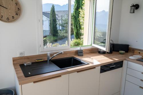 Il comprend une cuisine avec un évier et 2 grandes fenêtres. dans l'établissement Maison de Caroline et Julien- Vue Spectaculaire, à Saint-Jorioz