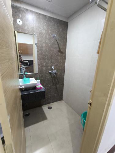 een badkamer met een douche, een wastafel en een spiegel bij Vision Studio Apartment in Ghaziabad