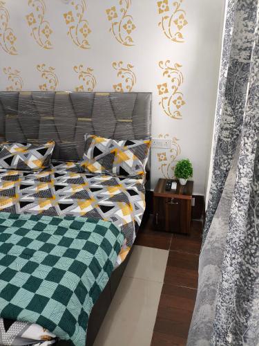 een slaapkamer met een bed met een groene en gele deken bij Vision Studio Apartment in Ghaziabad