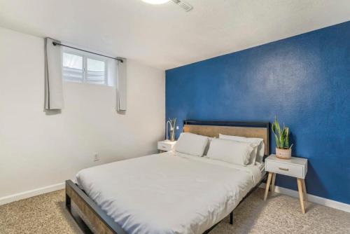 a bedroom with a large bed with a blue wall at Family Oasis Offices Home Gym Fenced Yard in Colorado Springs