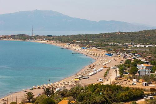 a view of a beach with umbrellas and the ocean at Assos Altın Hotel in Behramkale