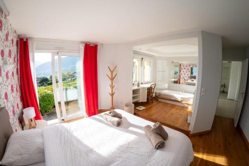 - une chambre avec un grand lit blanc et des rideaux rouges dans l'établissement Maison de Caroline et Julien- Vue Spectaculaire, à Saint-Jorioz