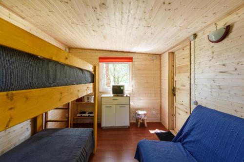 a bedroom with a bunk bed in a wooden house at Sodyba Brazylija in Taraldžiai