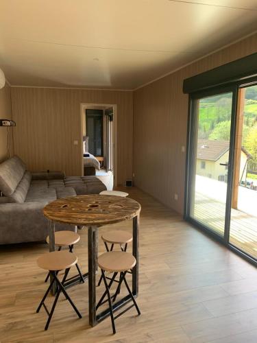 un salon avec une table, des chaises et un canapé dans l'établissement Massassi Plaza, à Cornimont