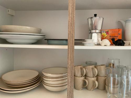 a shelf with plates and bowls and other dishes at Apartment Sommer am Faaker See in Faak am See