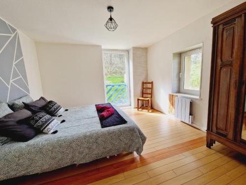 ein Schlafzimmer mit einem Bett mit Kissen darauf in der Unterkunft Le Petit Hangy in Fresse-sur-Moselle
