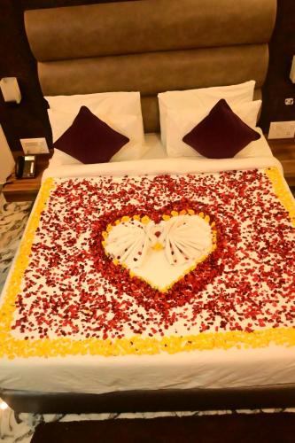 a large cake in the shape of a heart on a bed at Neil Holiday Resort in Neil Island