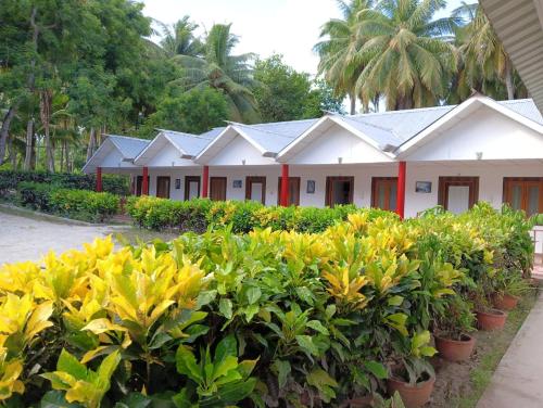 Une rangée de maisons avec des fleurs jaunes devant elles dans l'établissement Neil Holiday Resort, à Neil Island