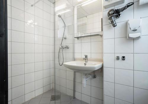 a white bathroom with a sink and a shower at Thon PartnerHotel Storgata in Kristiansund