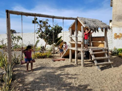 a group of children playing in a playground at Casa los Vientos de Vichayito in Los Órganos