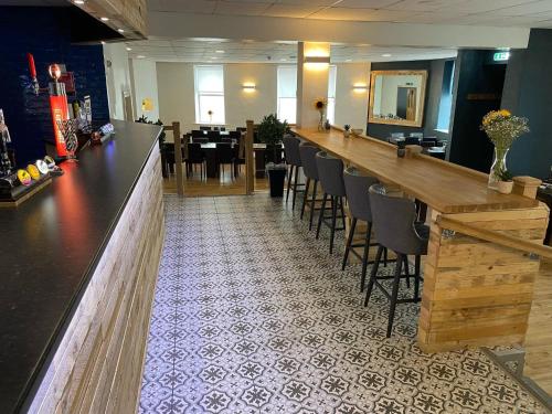 a bar in a restaurant with a table and chairs at Waverley Hotel in Workington