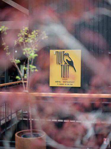 a sign in a window with a bird on it at Hôtel le Tuit-Tuit in La Plaine des Palmistes