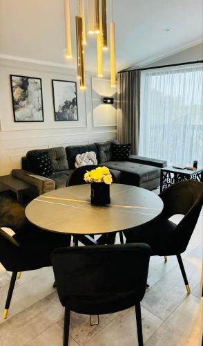 a living room with a table and a couch at Apartamenty BLUE BALTIC SPA Jacuzzi & Sauna MORZE in Chłopy