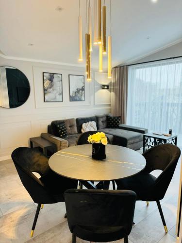 a living room with a table and chairs and a couch at Apartamenty BLUE BALTIC SPA Jacuzzi & Sauna MORZE in Chłopy