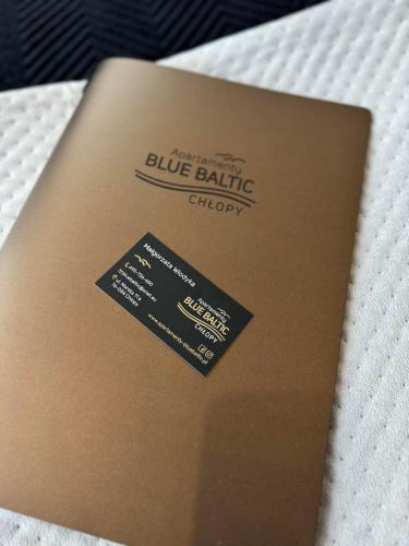 a brown book sitting on top of a bed at Apartamenty BLUE BALTIC SPA Jacuzzi & Sauna MORZE in Chłopy