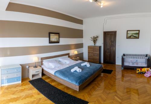 a bedroom with a bed and a striped wall at Sugovica Superior in Baja