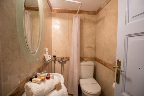a small bathroom with a toilet and a sink at Lithies Traditional Homes in Firostefani