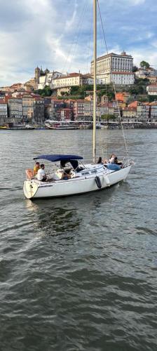 a white boat in the water with people on it at Navegar no Douro - Navegação e Turismo Unipessoal, Lda in Vila Nova de Gaia