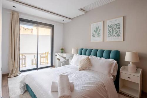 ein Schlafzimmer mit einem großen Bett und einem großen Fenster in der Unterkunft TT Holidays Cosy Apartment/ Casablanca City in Casablanca