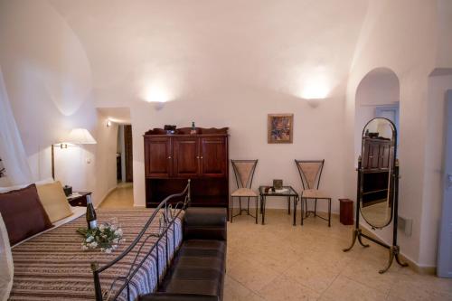 a living room with a bed and a mirror at Lithies Traditional Homes in Firostefani