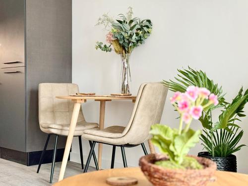 een tafel met 2 stoelen en een tafel met bloemen bij Apartment 27 city gate York in York