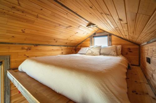 a bedroom in a log cabin with a large bed at Altitude - A Tiny House Experience in a Goat Farm in Romsey