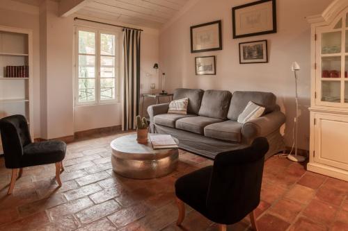 a living room with a couch and a table at HOTEL et APPARTEMENTS DOMAINE DES CLOS - Teritoria in Beaucaire