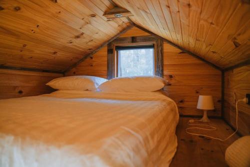 een slaapkamer met een bed in een blokhut bij Rendezvous Nexus in Toolangi