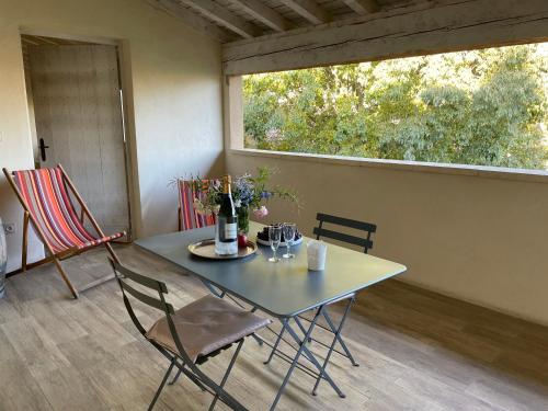 a table and chairs in a room with a window at HOTEL et APPARTEMENTS DOMAINE DES CLOS - Teritoria in Beaucaire
