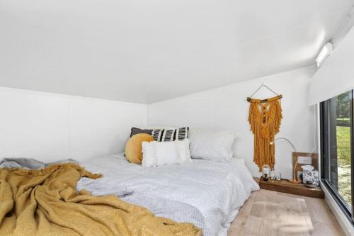 a bedroom with a bed with a blanket and a window at Azaltie in Kangaroo Valley