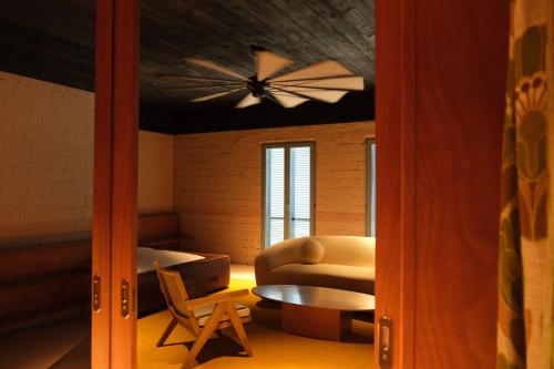 a living room with a ceiling fan and a table at Rooms Hotel Batumi in Batumi