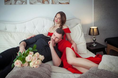 un hombre y una mujer acostados en una cama en La Vie - Apartmány, en Telč