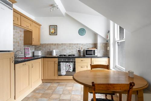 a kitchen with a wooden table and a table and a table at Apartment in the heart of Beer on Jurassic Coast in Beer