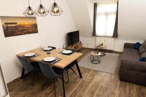 un soggiorno con tavolo e divano di BeMyGuest - 3 Zimmer Maisonette - Zentral - Klimaanlage - Aufzug a Wiesbaden