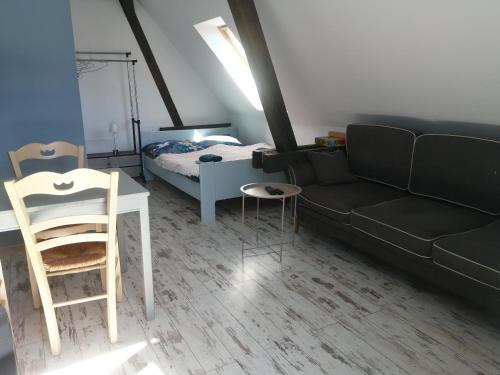 uma sala de estar com um sofá e uma cama em Włóczykijówka em Jarnołtówek