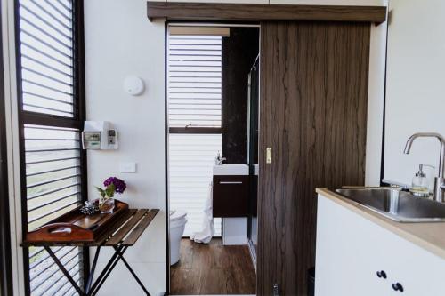 uma pequena cozinha com uma mesa e um lavatório em Belrose Estate em Dumbalk