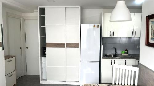 a kitchen with white cabinets and a refrigerator at Relax apartamento 5 in Las Palmas de Gran Canaria