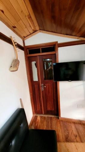 a living room with a flat screen tv and a door at Ugatrac tours and travel in Kampala