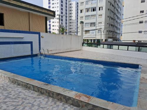 - une grande piscine bleue au-dessus d'un bâtiment dans l'établissement Apto Aconchegante, à Praia Grande