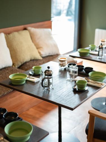 a wooden coffee table with green bowls and cups on it at Hôtel le Tuit-Tuit in La Plaine des Palmistes