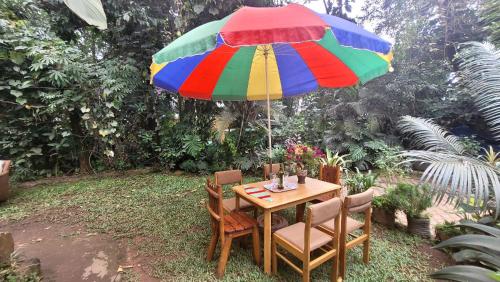 a table with a colorful umbrella in a garden at Ugatrac tours and travel in Kampala
