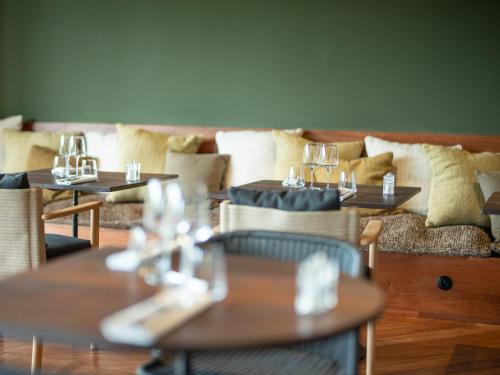 a restaurant with tables and couches with glasses on them at Hôtel le Tuit-Tuit in La Plaine des Palmistes