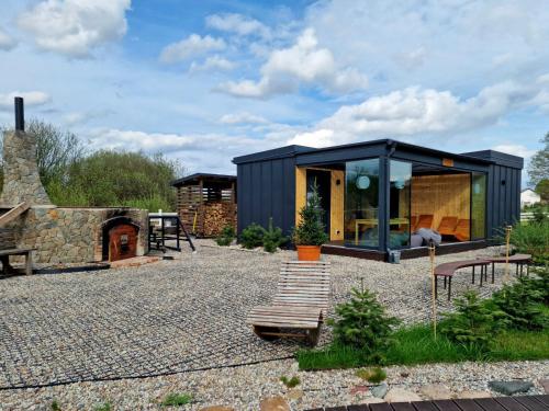a black container house with a bench and a fireplace at Lisi Ogon zanurzeni w naturze in Lisi Ogon