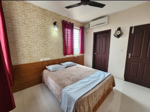a bedroom with a bed and a ceiling fan at Sharon Holidays Near LULU in Trivandrum