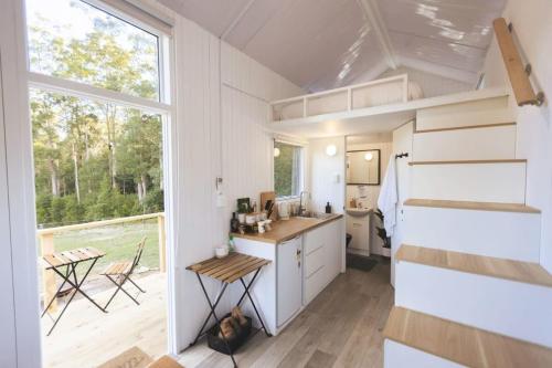 a tiny house with a kitchen and a large window at Kookaburra Cabin in Palmwoods