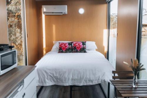 um pequeno quarto com uma cama e uma televisão em Bush Retreat em Alberton West