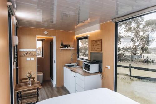 uma pequena cozinha com um lavatório e um micro-ondas em Bush Retreat em Alberton West