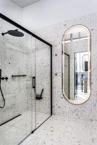 a bathroom with a shower and a mirror at Vilnius TV Tower Apartments DEBESYS in Vilnius