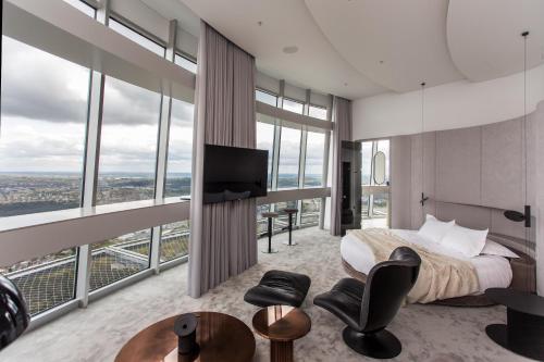 a bedroom with a king sized bed and large windows at Vilnius TV Tower Apartments DEBESYS in Vilnius